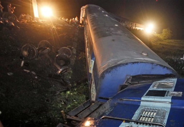 A derailed passenger train is seen off the track near Bhatkuchi, about 70 km (43 miles) west of Gauhati, India early Monday, July 11, 2011. At least fifty passengers were injured as four coaches of the Guwahati-Puri Express derailed following a possible explosion, local police and railway sources said. (AP Photo/Anupam Nath)
